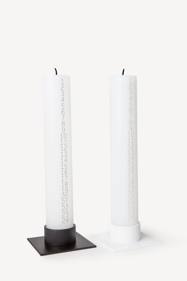 Traditional Danish Christmas countdown pillar candle with black or gold numbers for holidays and gifts shown with candle holder