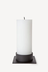 Hand poured Danish unscented white pillar candles available in three sizes for everyday use shown with matching black candle holder