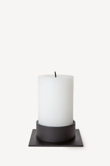 Hand poured Danish unscented white pillar candles available in three sizes for everyday use shown with matching black candle holder