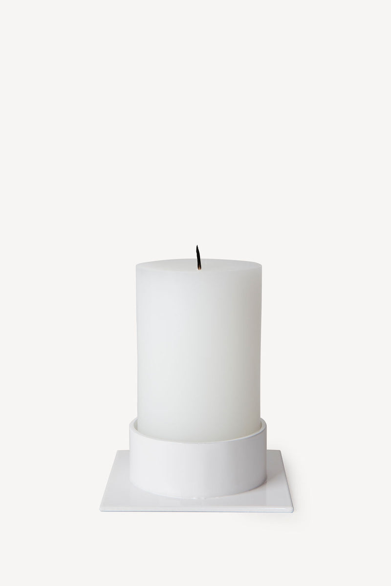 Hand poured Danish unscented white pillar candles available in three sizes for everyday use shown with matching white candle holder
