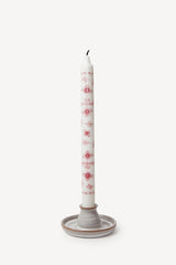 Authentic Royal Copenhagen decorative taper candles in red paired with a clay candle holder.