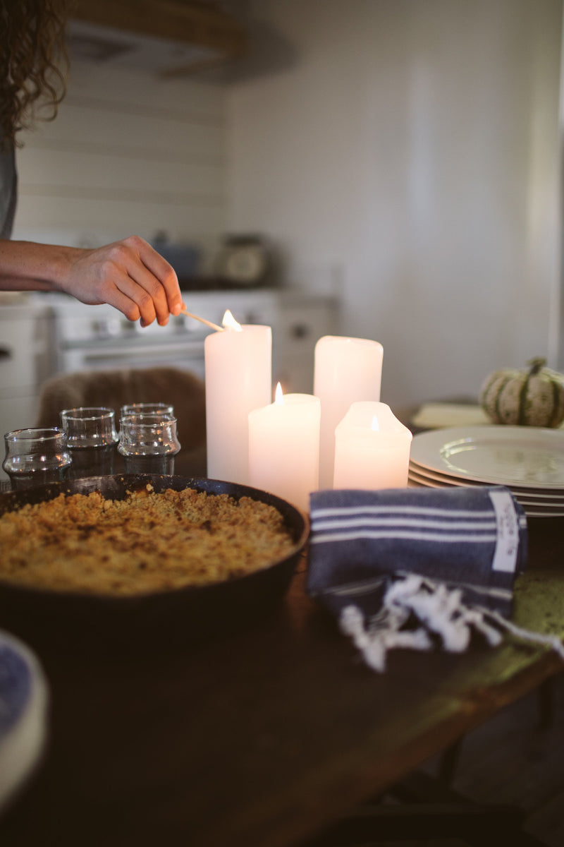 Hand poured Danish unscented white pillar candles available in three sizes for everyday use on a dining room table centerpiece